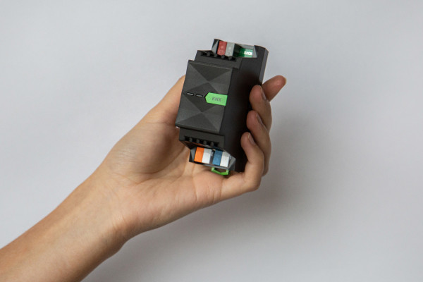 Kleine Hutschieneneinheit im Handformat Person hält kompakte Hutschieneneinheit in der Hand